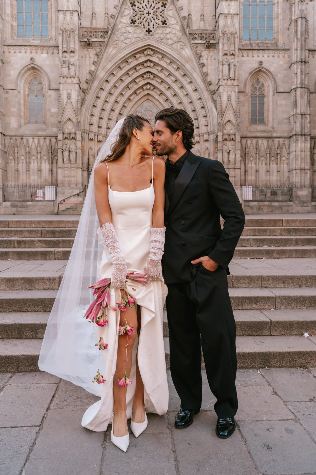 Bride and groom nose to nose in front of the cathedral
